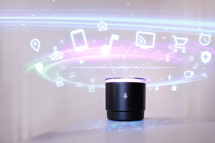 Small, black home automation device with holographic overlay of the various tasks it can accomplish.
