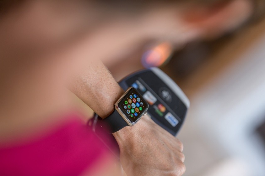 Person using Apple Watch and an electronic reader.