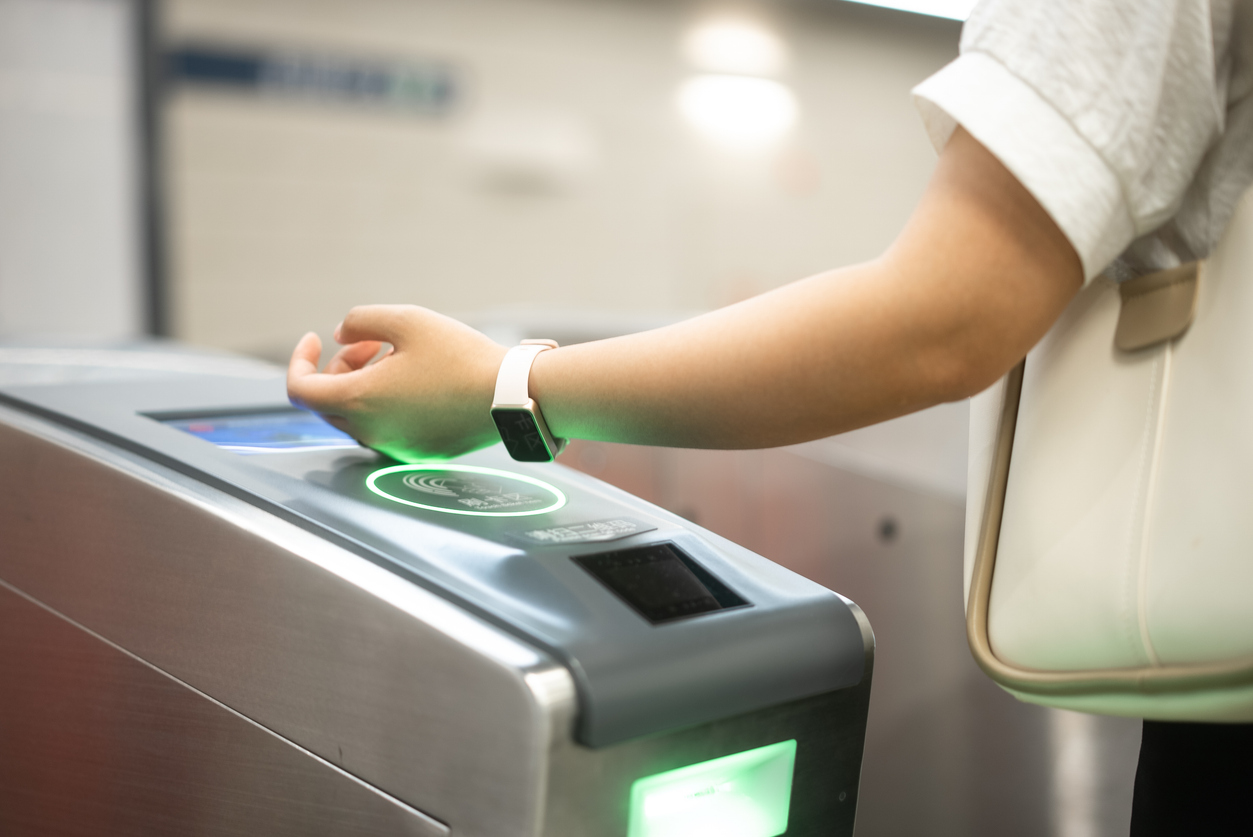 Person checking in at a Subway restaurant using a smartwatch for contactless access or payment