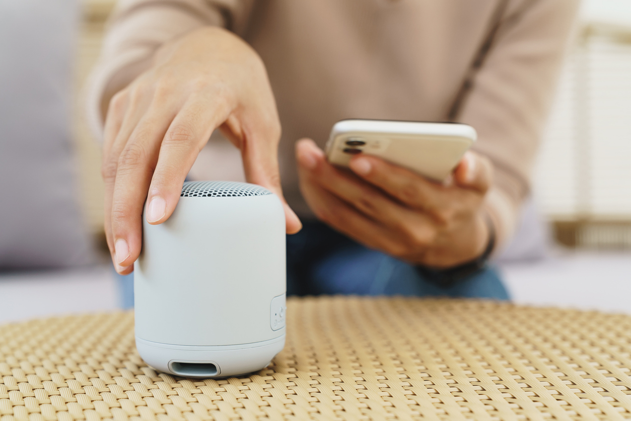Person connecting a Bluetooth speaker to a smartphone.