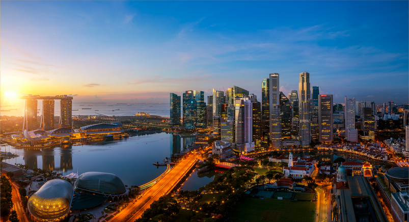 Singapore skyline featuring city traffic and a vibrant sunrise in the background